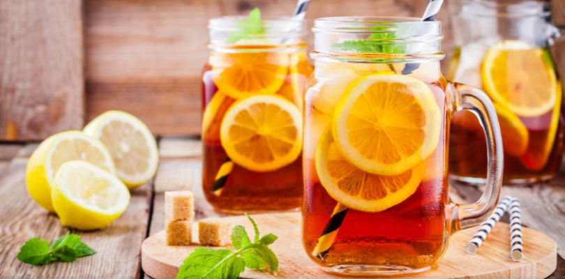 Glass mugs of iced tea with lemon slices.